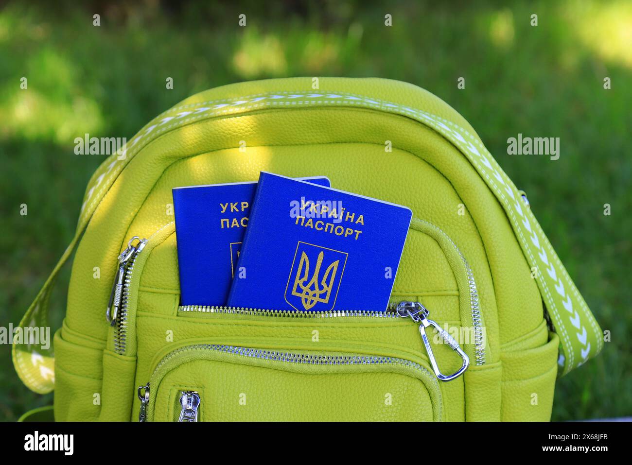 2 passeports de citoyens de l'Ukraine avec une inscription en ukrainien - passeport de l'Ukraine se trouve dans le sac à dos vert. Concept de voyage, réfugiés, tourisme Banque D'Images