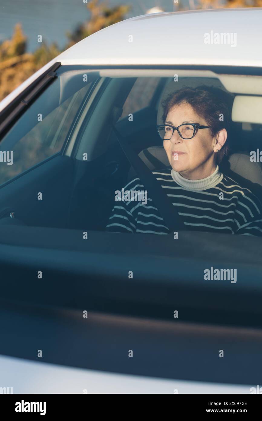 Portrait d'une femme sur le siège passager profitant de la vue sur un voyage en voiture. Banque D'Images