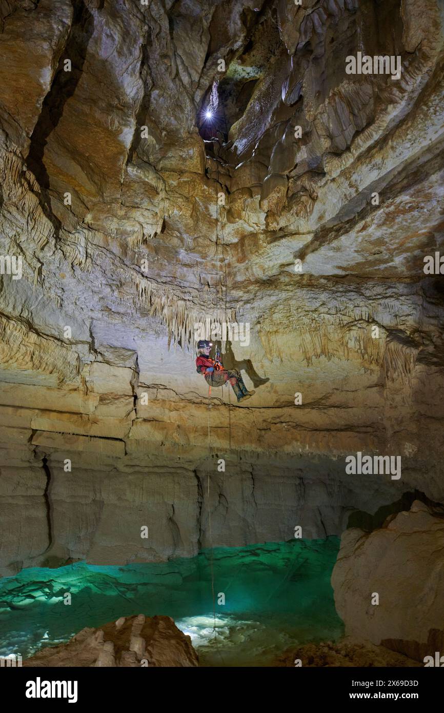 Spéléologue descendant en rappel dans une grotte Banque D'Images