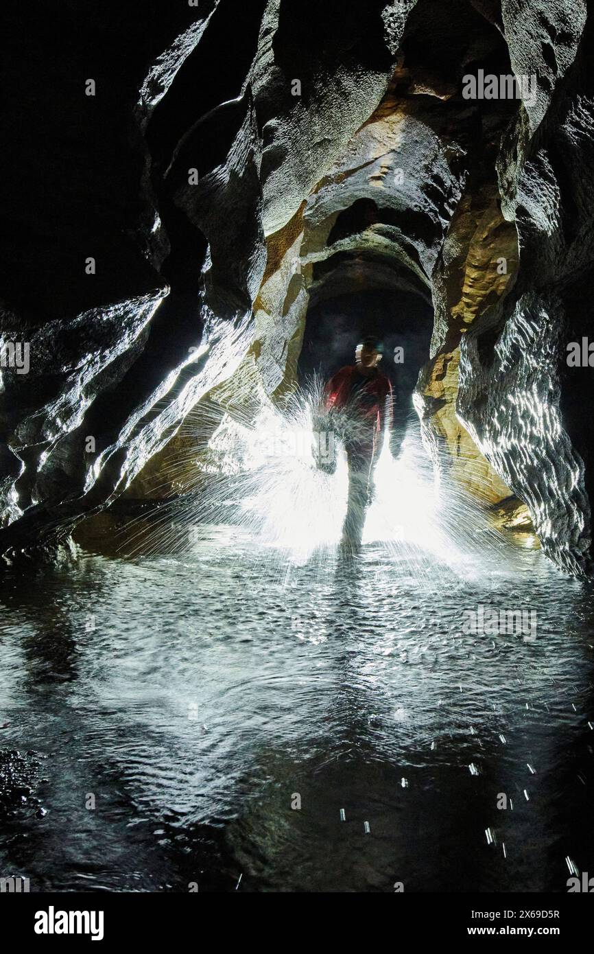 Spelunkers dans une grotte, éclaboussures d'eau Banque D'Images