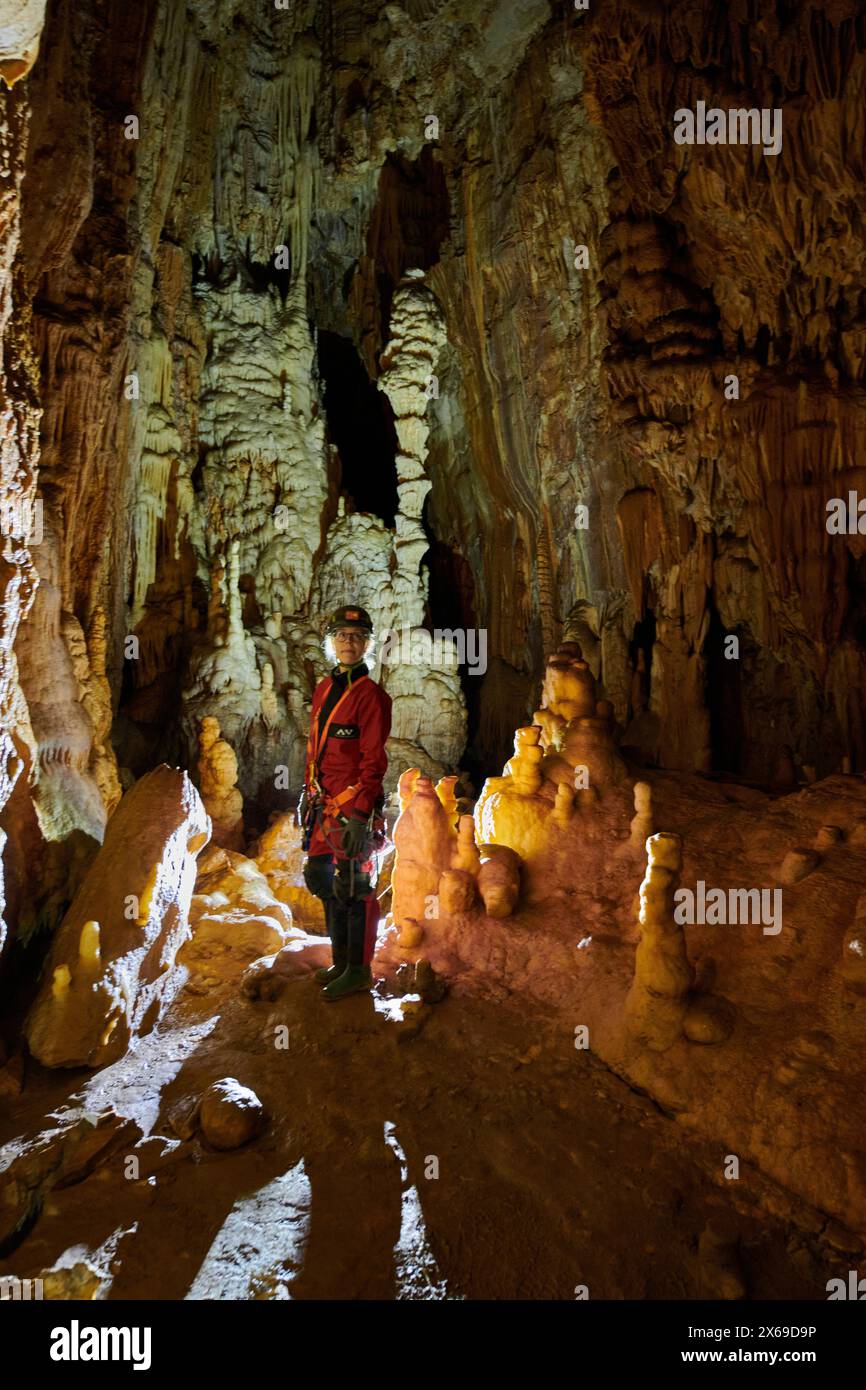 Explorateur de grottes entre stalactites Banque D'Images
