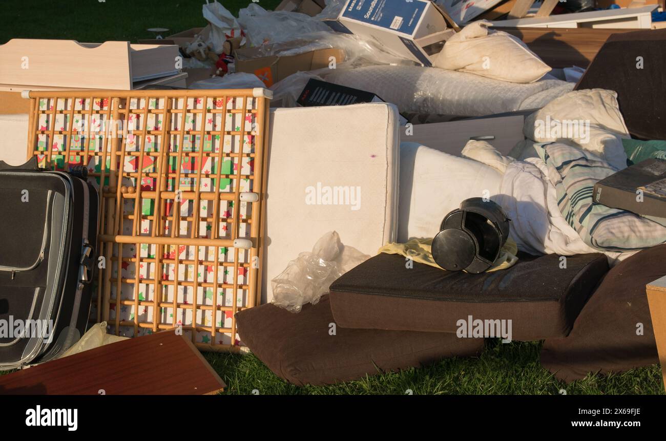Déchets dans une ville près de la maison. Grandes ordures avec vieux meubles en bois, jouets, boîtes, sacs en plastique dans une rue dans la journée ensoleillée de décharge de déchets en Allemagne. Banque D'Images