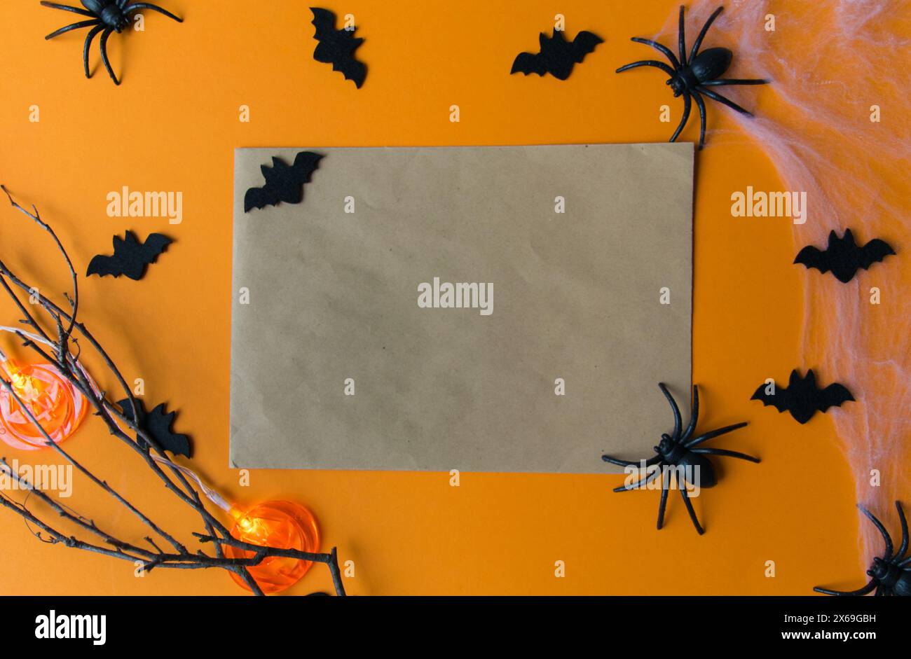Décorations d'Halloween avec citrouilles, chauves-souris, web, insectes sur fond orange. Carte de fête avec espace de copie. Banque D'Images
