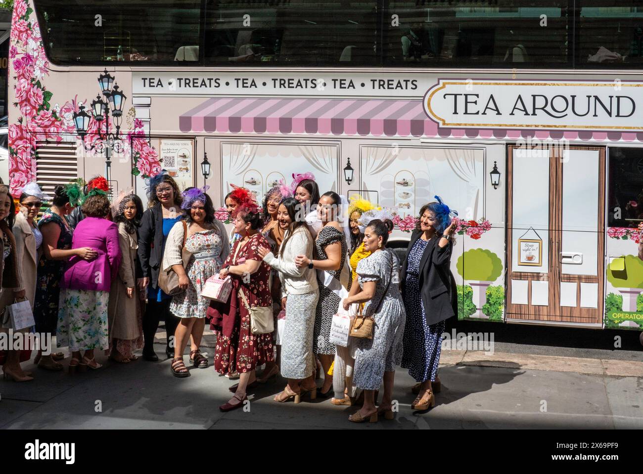 Des femmes bien habillées posent pour des photos devant le bus de fête 'tea around Town' le 42e à Midtown Manhattan par une journée ensoleillée, NYC, USA Banque D'Images