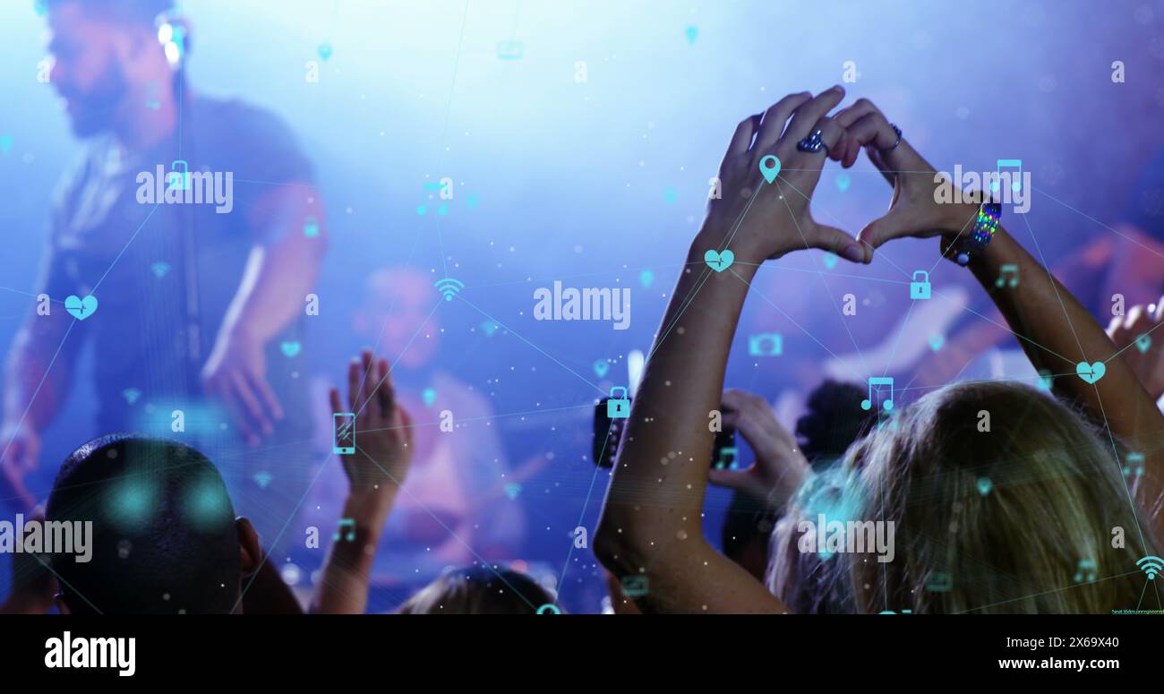 Un groupe diversifié de jeunes dansent au concert, entourés d'icônes numériques Banque D'Images