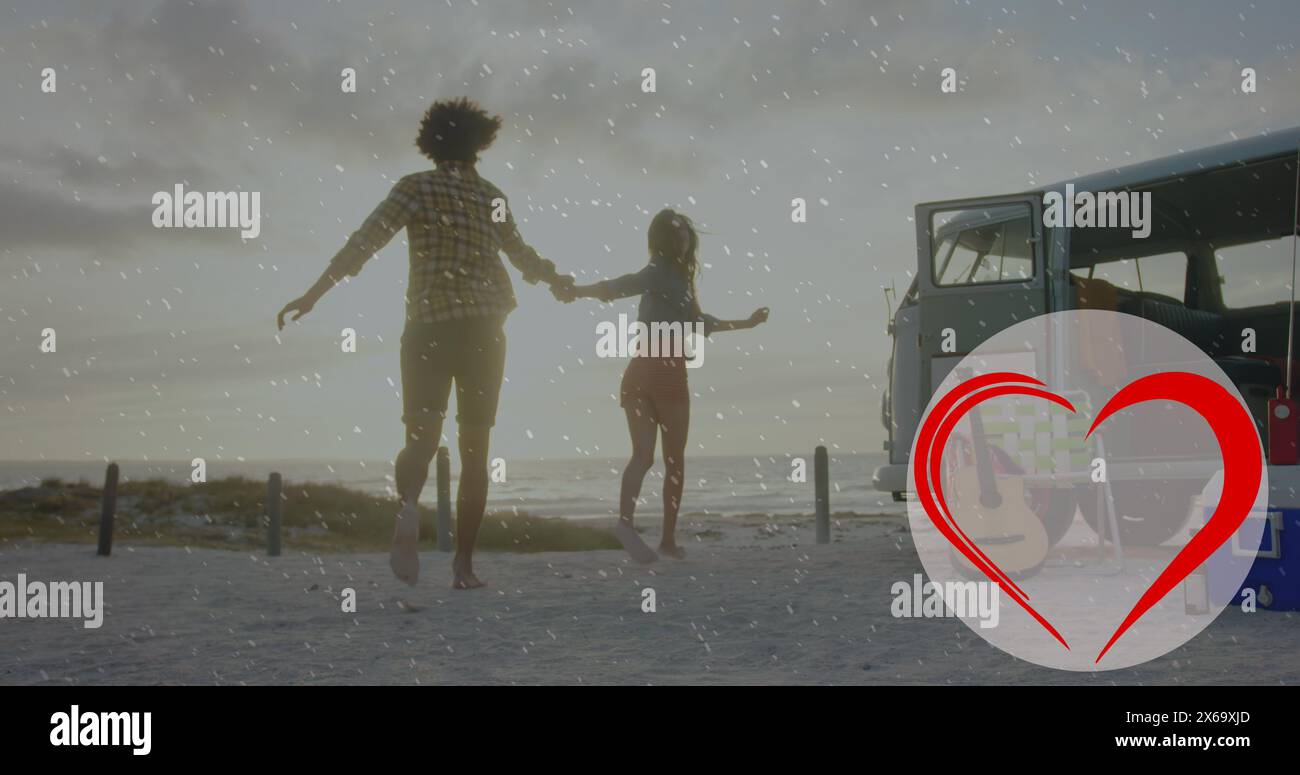 Image de l'icône de coeur sur un couple diversifié dans l'amour courir sur la plage Banque D'Images