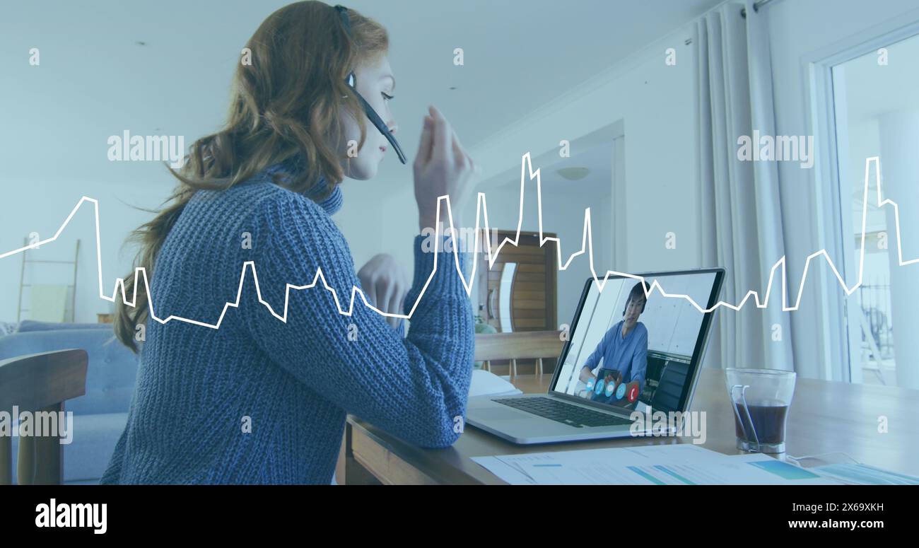 Image du traitement des données sur graphique sur une femme caucasienne à la maison faisant appel à l'image d'ordinateur portable Banque D'Images