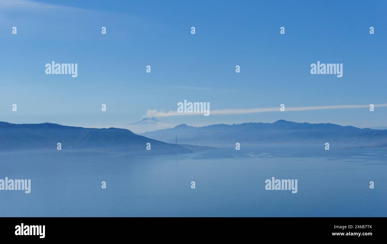 Baie méditerranéenne vue du point de vue de Monte Sant'Elia pendant la journée avec de la fumée s'élevant du volcan actif Etna en Sicile, Palmi, Calabre, Italie Banque D'Images