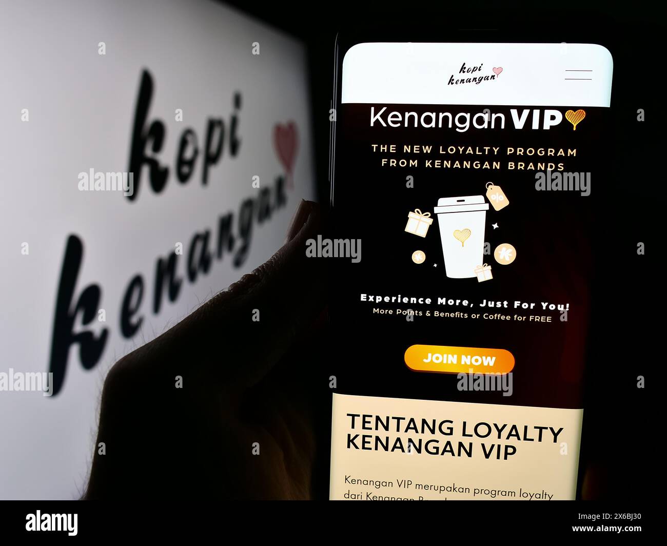 Personne tenant le téléphone portable avec la page Web de la société de chaîne de café indonésienne Kopi Kenangan devant le logo. Concentrez-vous sur le centre de l'écran du téléphone. Banque D'Images