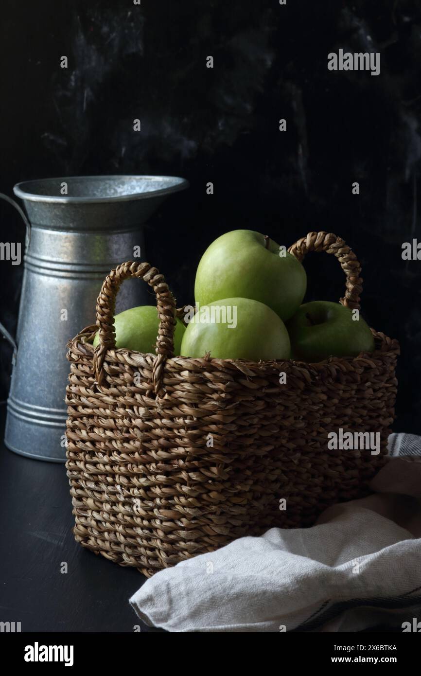 Pommes vertes dans un panier sur un fond noir Banque D'Images