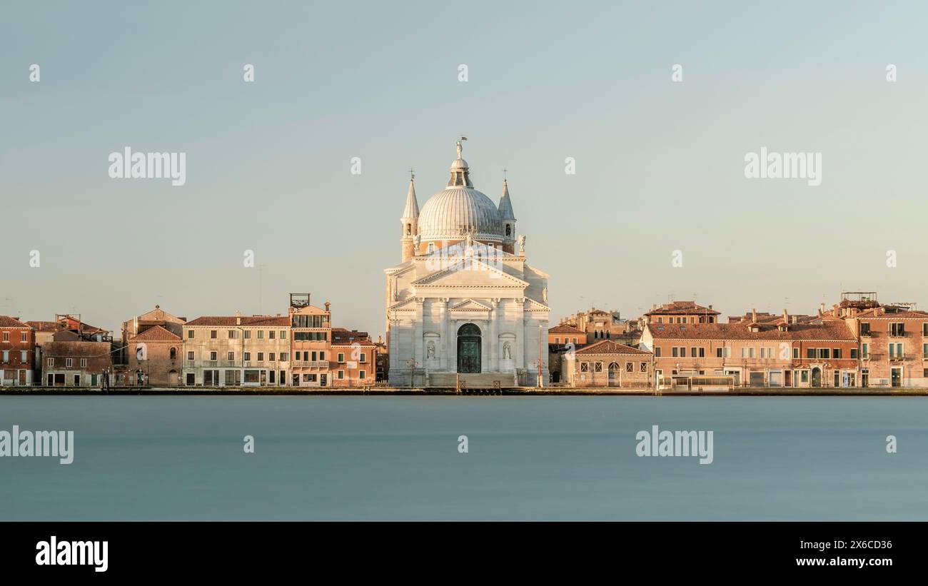 Chiesa del Santissimo Redentore Eglise catholique et rangée de bâtiments sur le remblai fondamenta du canal de l'île de Giudecca dans la lagune vénitienne, au lever du soleil Banque D'Images