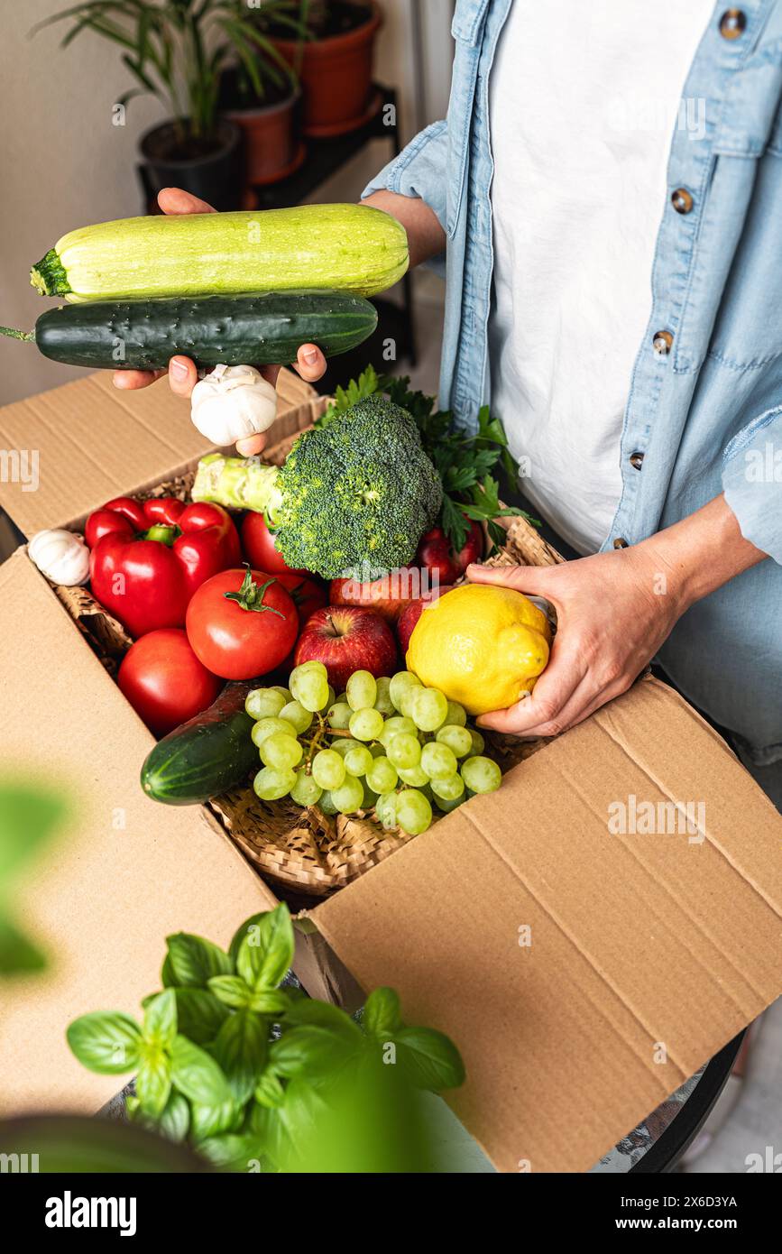 Livraison à domicile de légumes biologiques cultivés à la ferme. Déballer une alimentation saine et des légumes bio. Banque D'Images