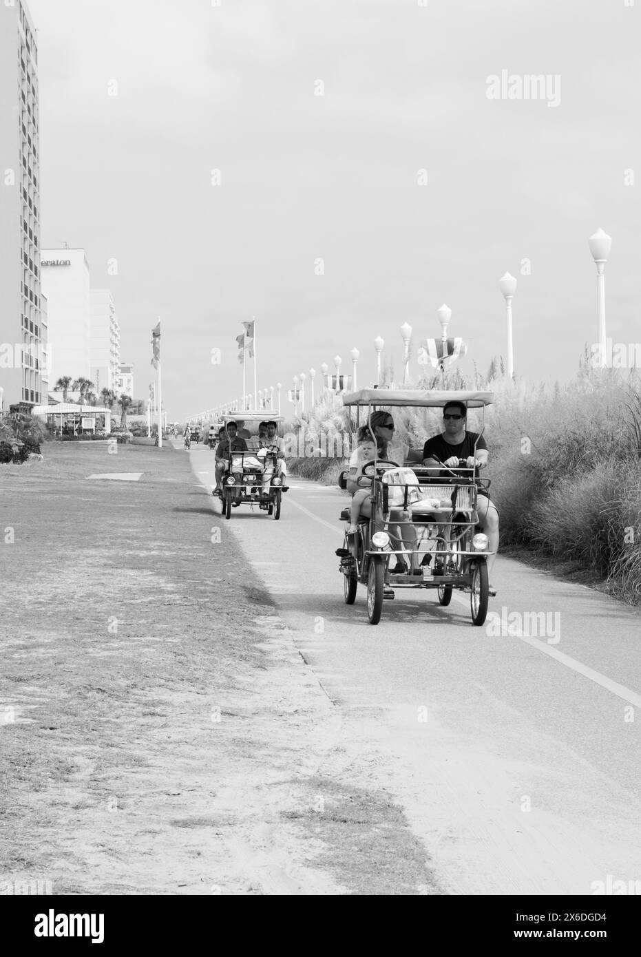 Touristes appréciant un tour sur des vélos de type voiture familiale à Virginia Beach sur Chesapeake Bay, États-Unis. Banque D'Images
