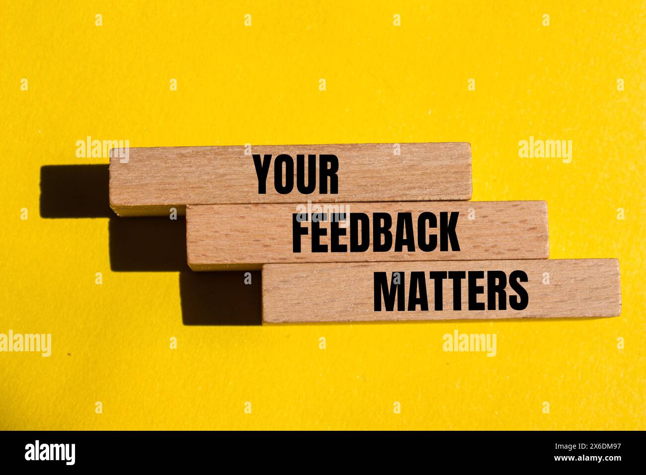 Vos commentaires sont importants écrits sur des blocs de bois avec un fond jaune. Conceptuel votre feedback est important. Copier l'espace. Banque D'Images