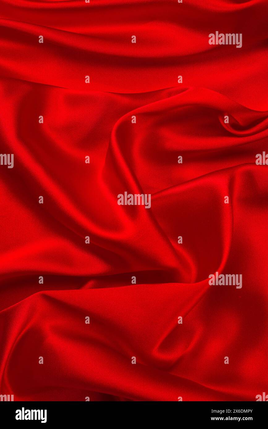 La texture en soie rouge ou en satin de luxe peut être utilisée comme arrière-plan abstrait. Vue de dessus. Banque D'Images
