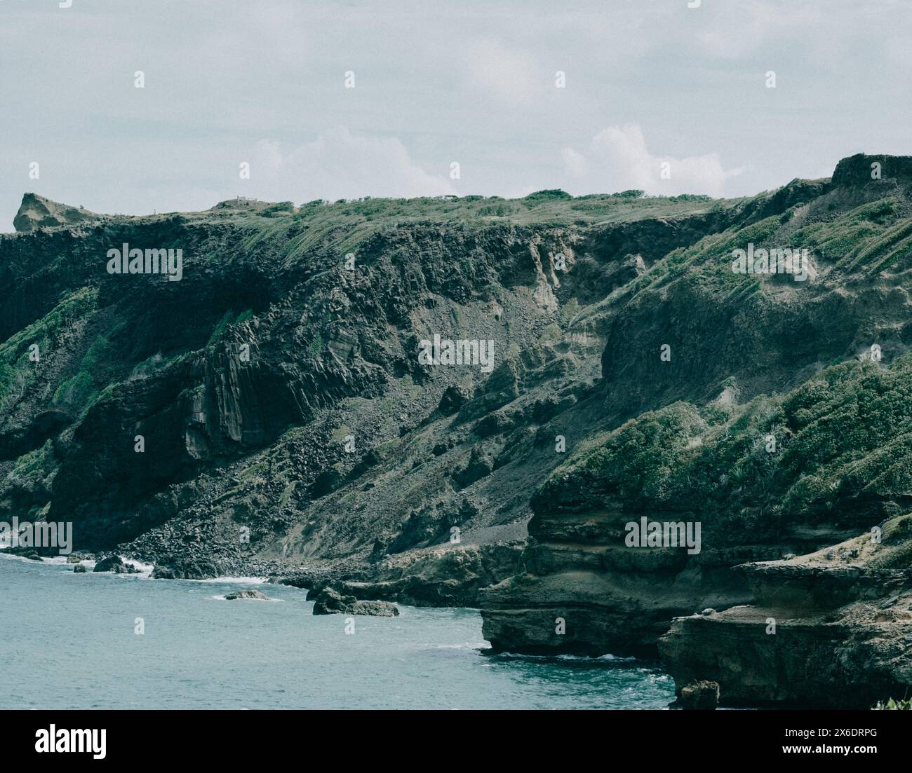 Falaises rocheuses époustouflantes le long de la côte de la Martinique, mettant en valeur les formations géologiques spectaculaires et la beauté naturelle de l'île Banque D'Images