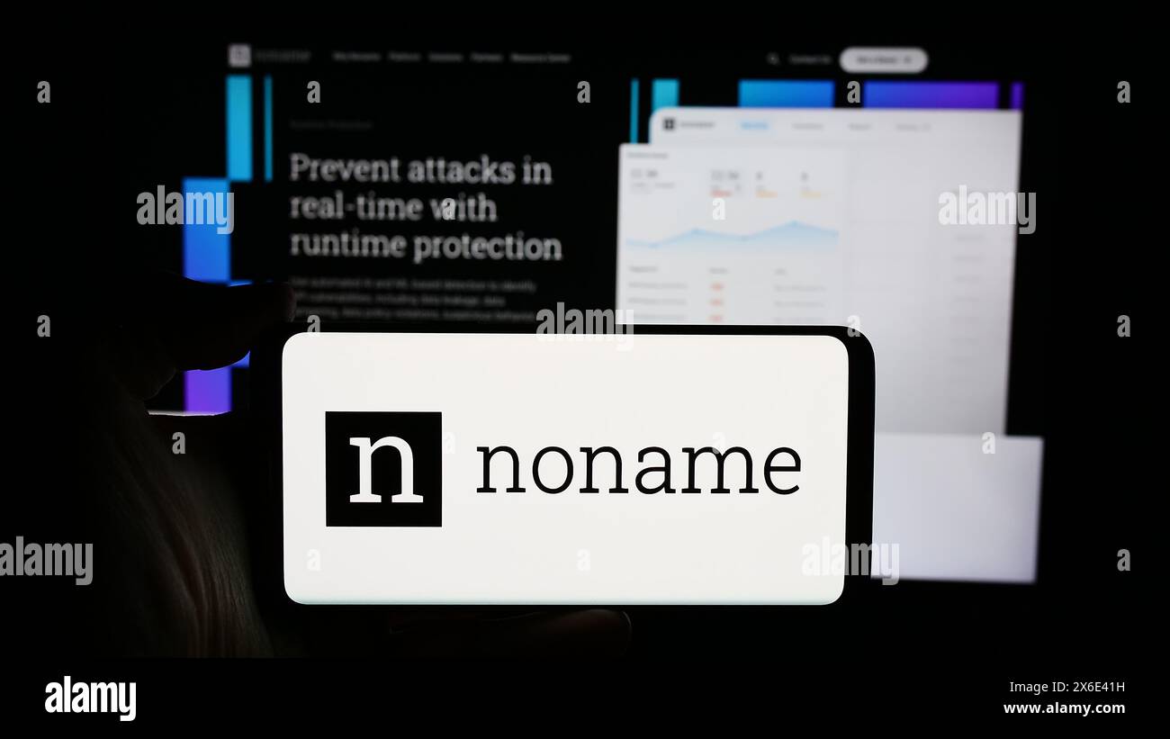 Personne tenant un téléphone portable avec le logo de la société américaine de cybersécurité Noname Security devant la page Web de l'entreprise. Concentrez-vous sur l'affichage du téléphone. Banque D'Images