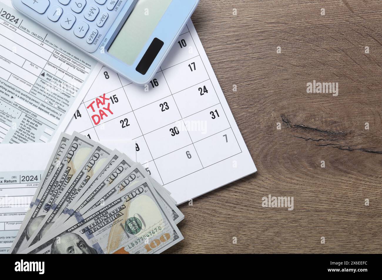 Calendrier avec rappel de date sur le jour de l'impôt, les documents, l'argent et la calculatrice sur la table en bois, vue de dessus. Espace pour le texte Banque D'Images