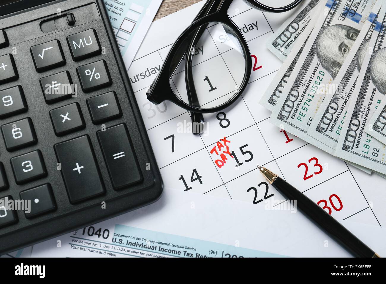 Calendrier avec rappel de date sur le jour des impôts, documents, argent, stylo, calculatrice et lunettes sur la table, vue de dessus Banque D'Images