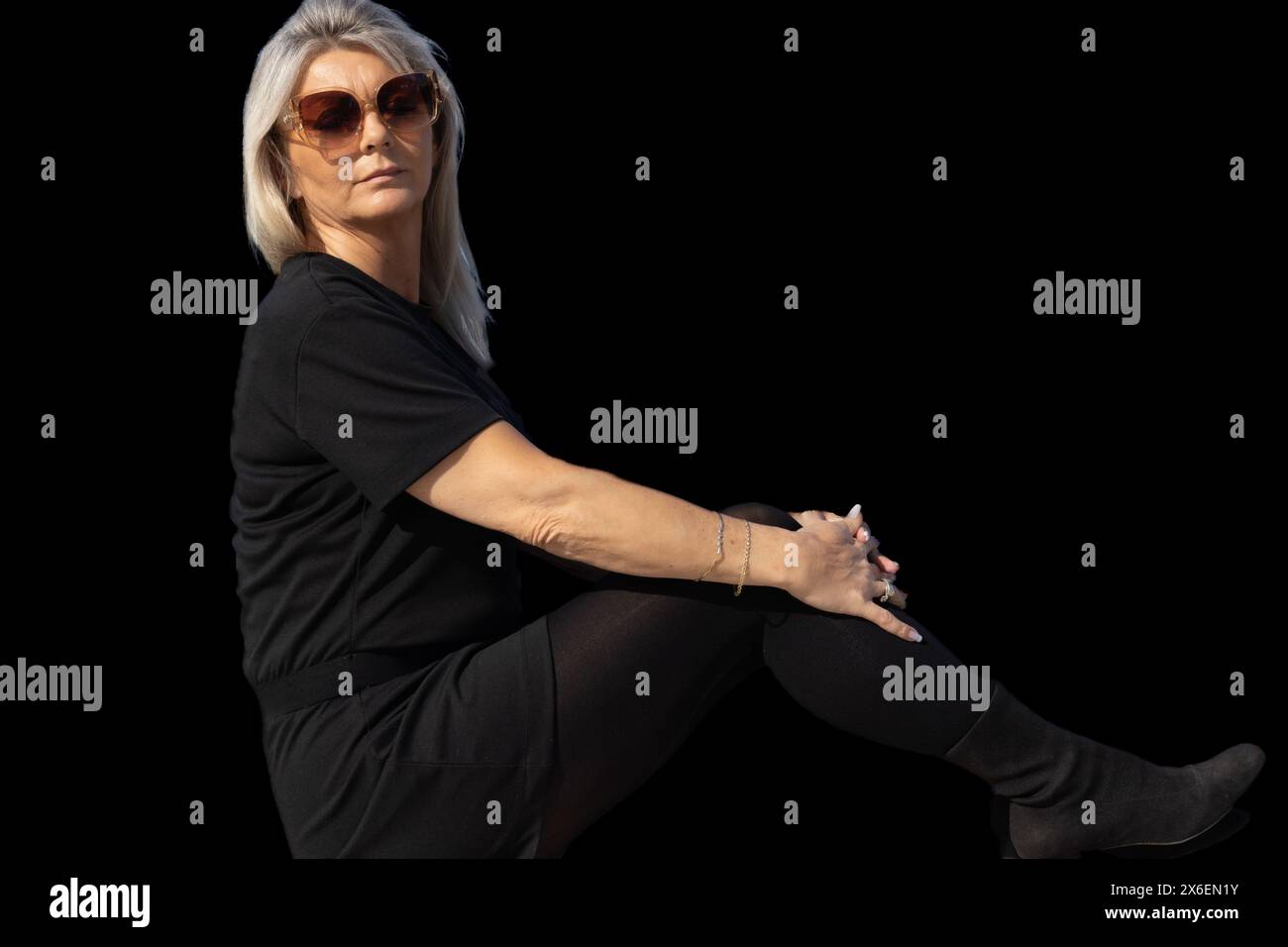 Ce portrait capture l’essence du charme sophistiqué d’une femme de 50 ans. Sa silhouette, définie par les lignes élégantes de sa tenue vestimentaire et le ch Banque D'Images