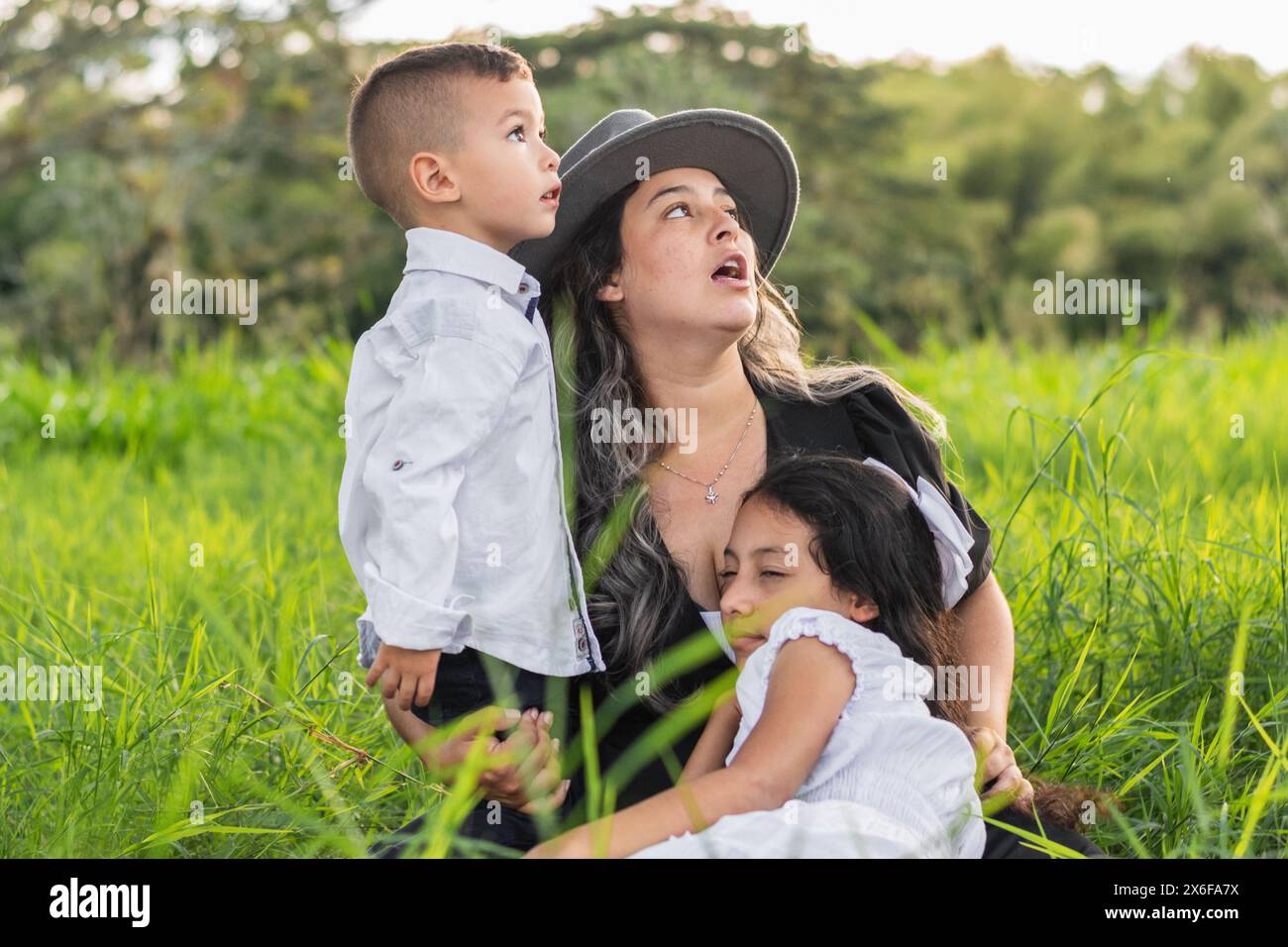 jeune femme avec ses deux enfants regardant le ciel très impressionnés par ce qu'ils voient ci-dessus Banque D'Images