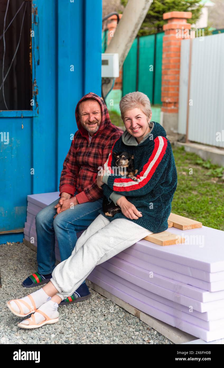 Couple marié russe mature embrassant et tenant un chien Banque D'Images