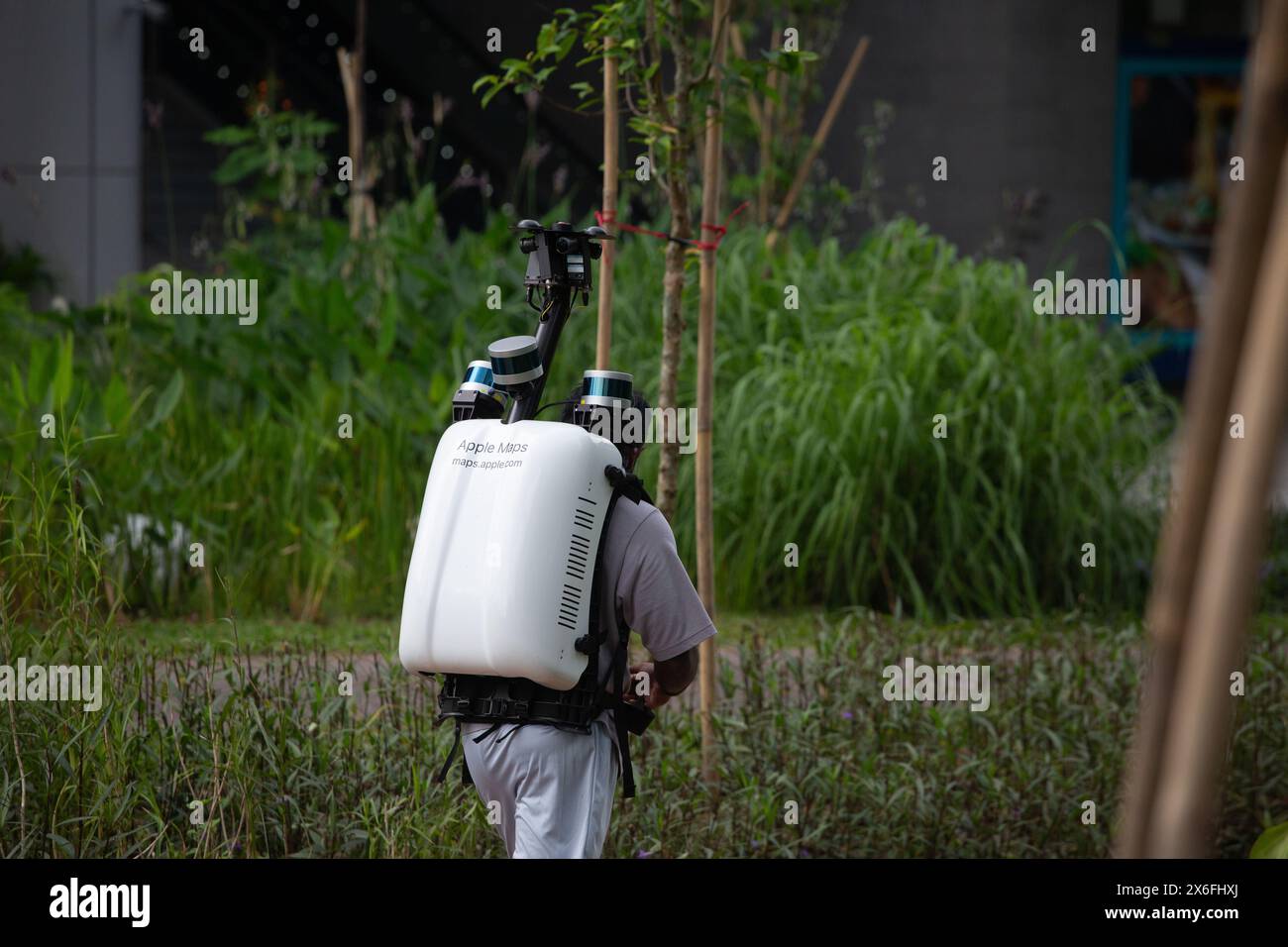 Un homme porte un sac à dos électronique lourd Apple Maps monté quatre caméras dessus pour prendre des photos pendant qu'il marche le long d'un itinéraire désigné. Singapour. Banque D'Images