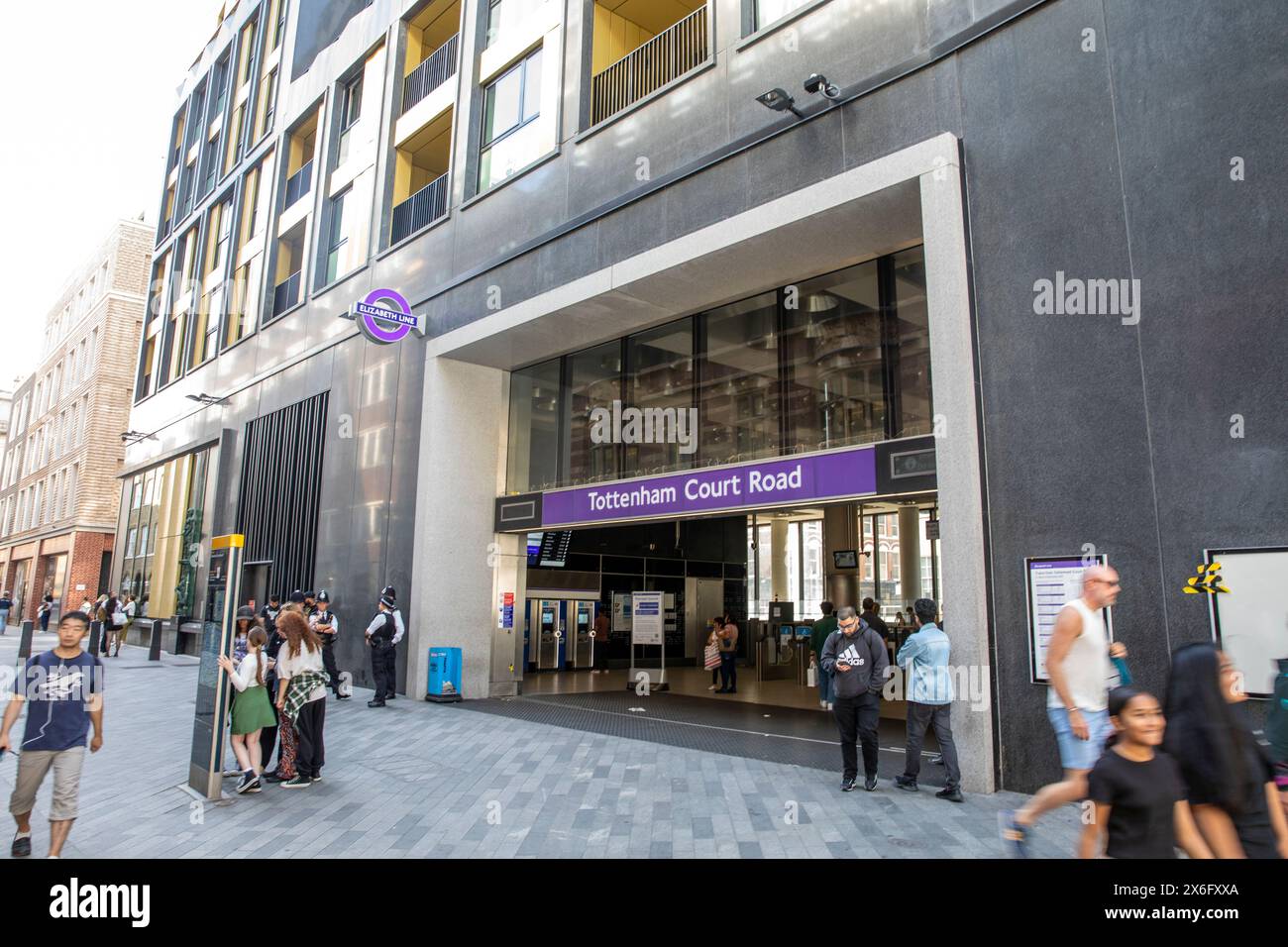 Tottenham court Road gare entrée Elizabeth Line, quatre policiers se tiennent à côté de l'entrée que les navetteurs entrent dans la gare, Londres, Royaume-Uni Banque D'Images