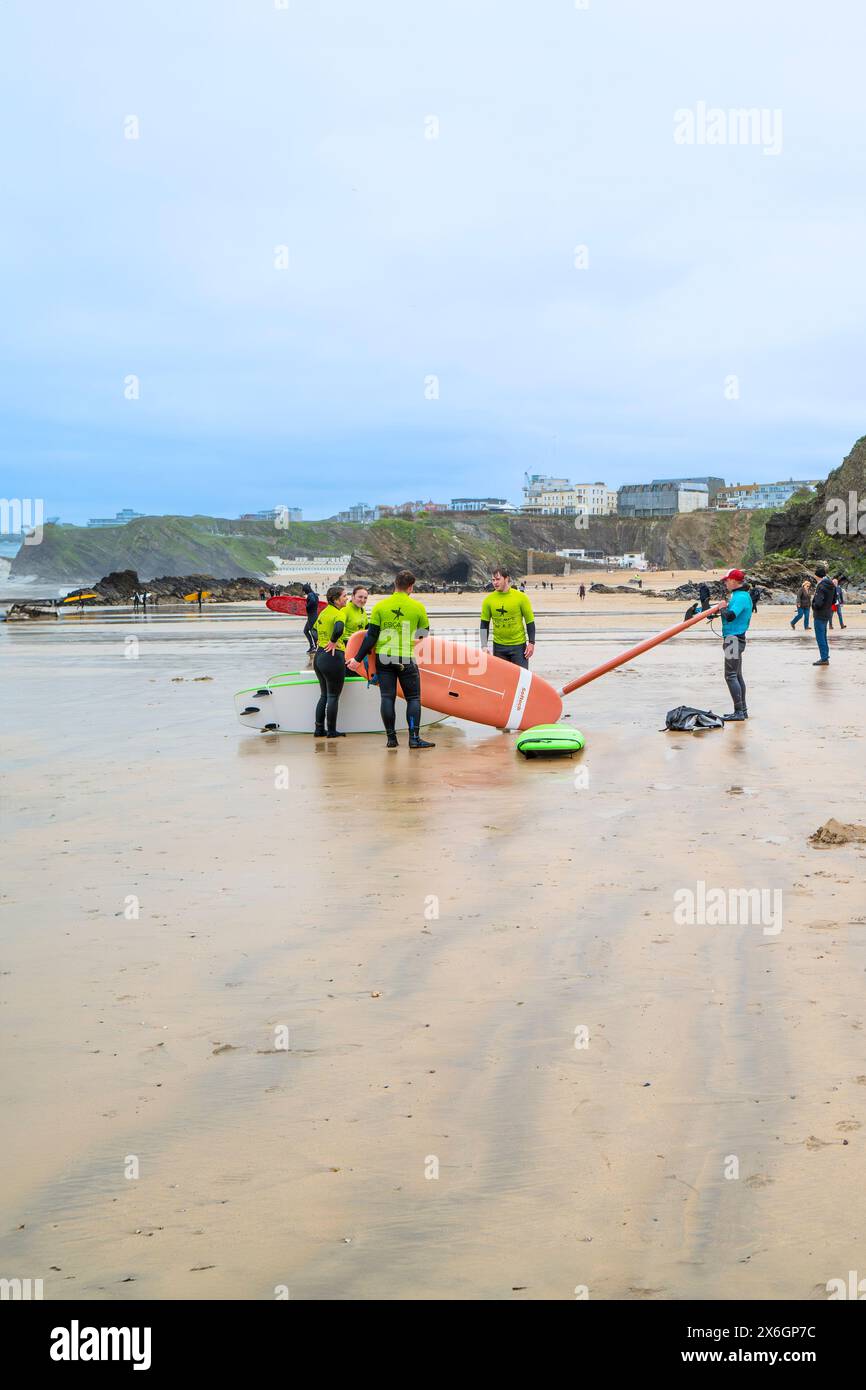 Un instructeur de surf de l'Escape Surf School marchant avec un groupe de surfeurs débutants sur la plage de Towan à Newquay en Cornouailles au Royaume-Uni. Banque D'Images