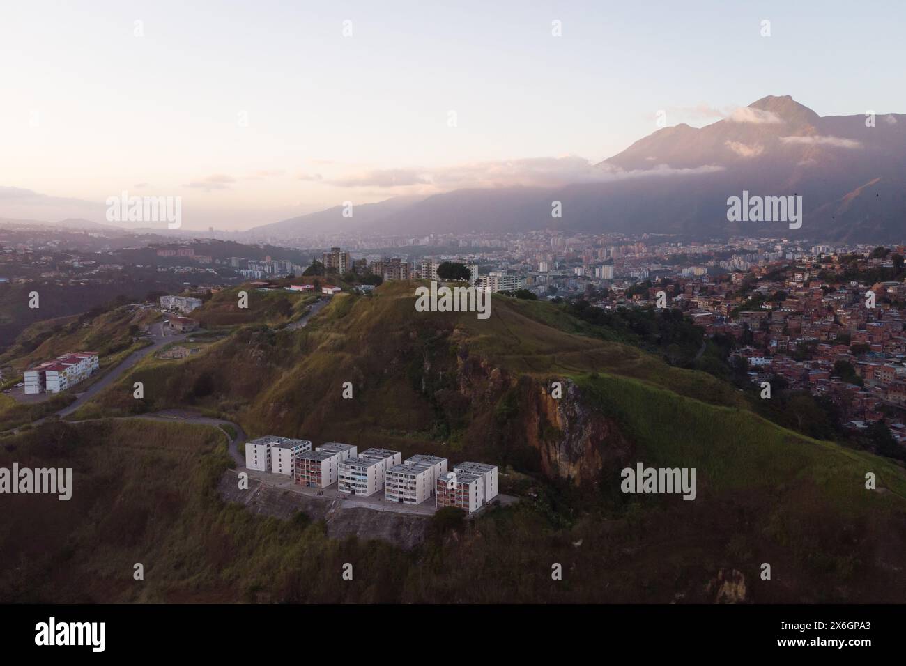 Vue aérienne de Caracas au coucher du soleil avec le quartier Petare, le plus grand bidonville du Venezuela et d'amérique latine, avec la montagne Avila dans l'arrière-pays Banque D'Images