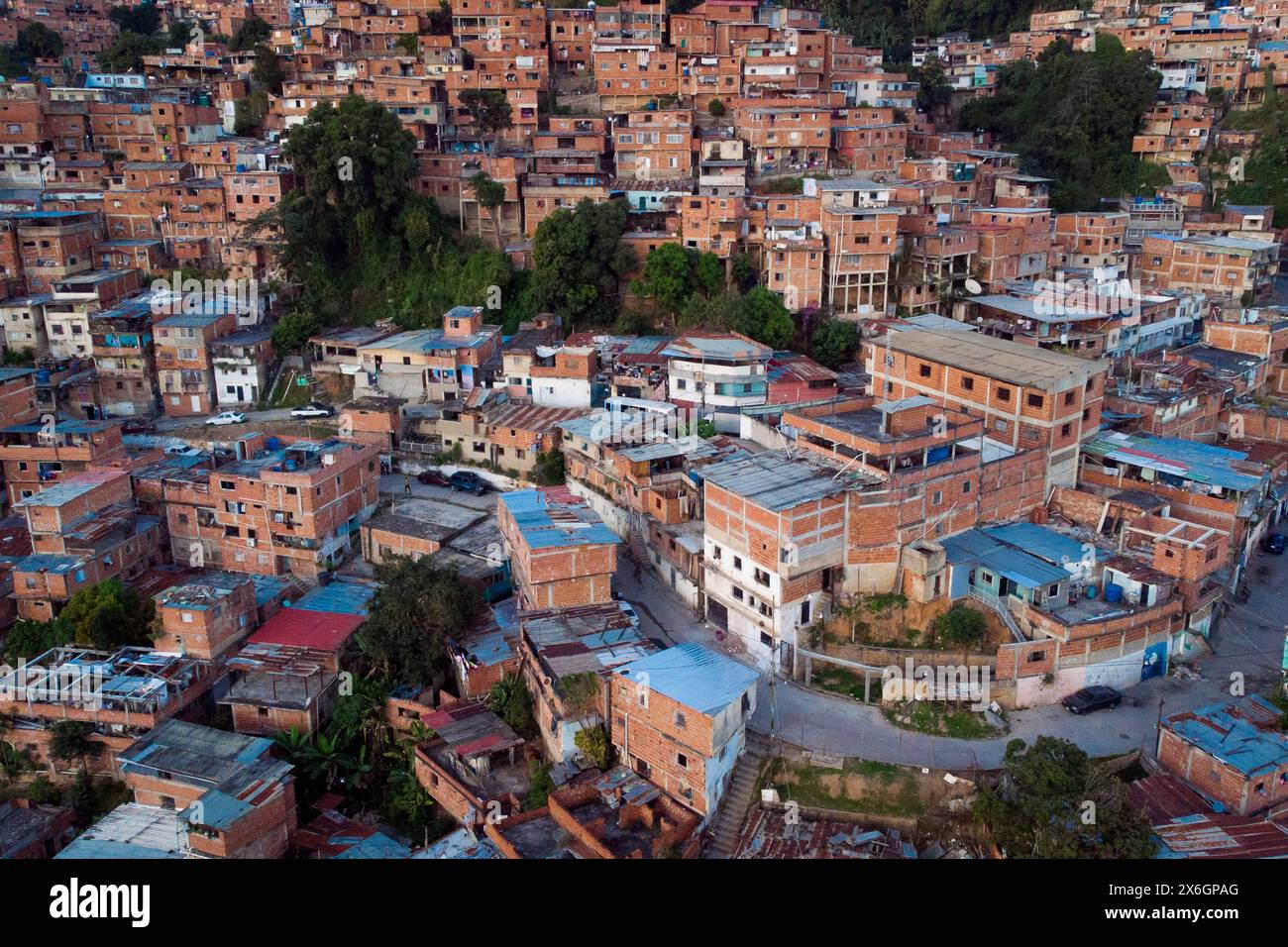 Vue aérienne de Caracas au coucher du soleil avec le quartier Petare, le plus grand bidonville du Venezuela et d'amérique latine, avec la montagne Avila dans l'arrière-pays Banque D'Images