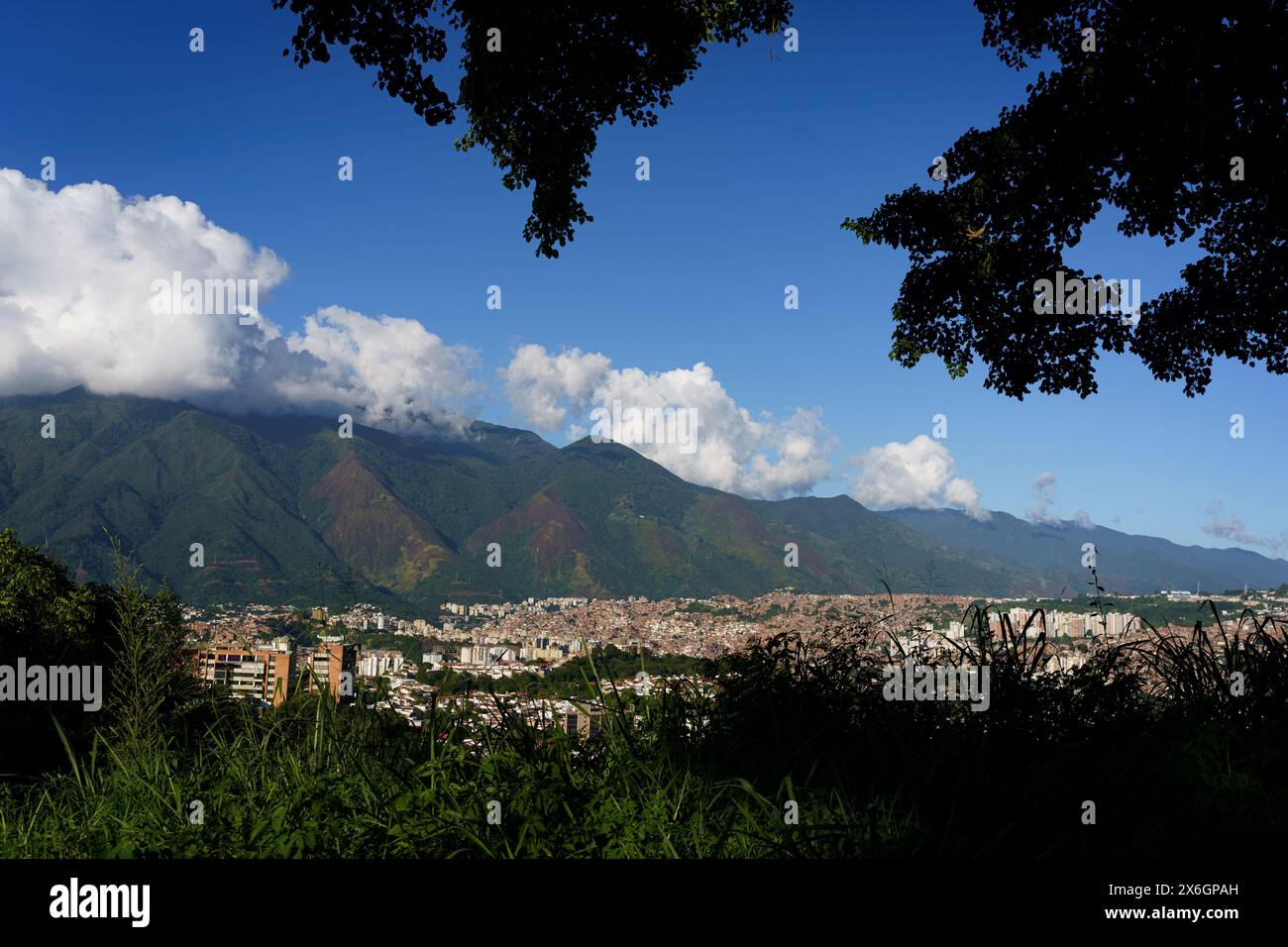 Vue aérienne de Caracas au coucher du soleil avec le quartier Petare, le plus grand bidonville du Venezuela et d'amérique latine, avec la montagne Avila dans l'arrière-pays Banque D'Images