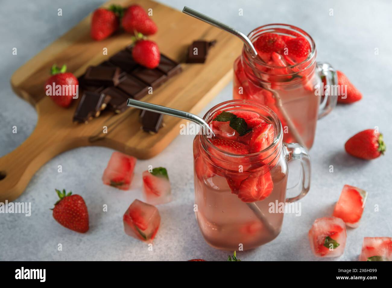 Boisson rafraîchissante à la fraise avec des baies et une planche de bois avec du chocolat noir. Boisson aux fruits et concept sain Banque D'Images