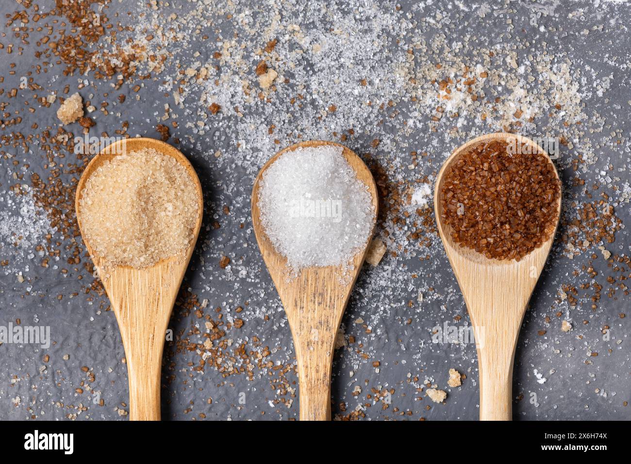 Différents types de sucre dans des cuillères en bambou, complet, blanc et aromatisé à la réglisse Banque D'Images