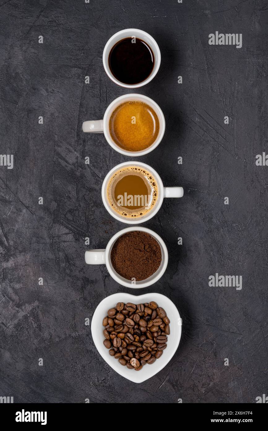 Vue de dessus. Certains types de café dans différentes tasses disposées en rangée verticale sur un fond noir Banque D'Images