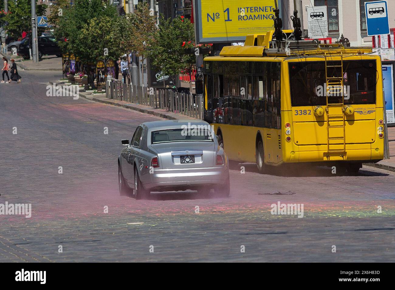 Kiev, Ukraine - 10 juillet 2018 : trolleybus jaune et une voiture chère dans une rue de Kiev Banque D'Images