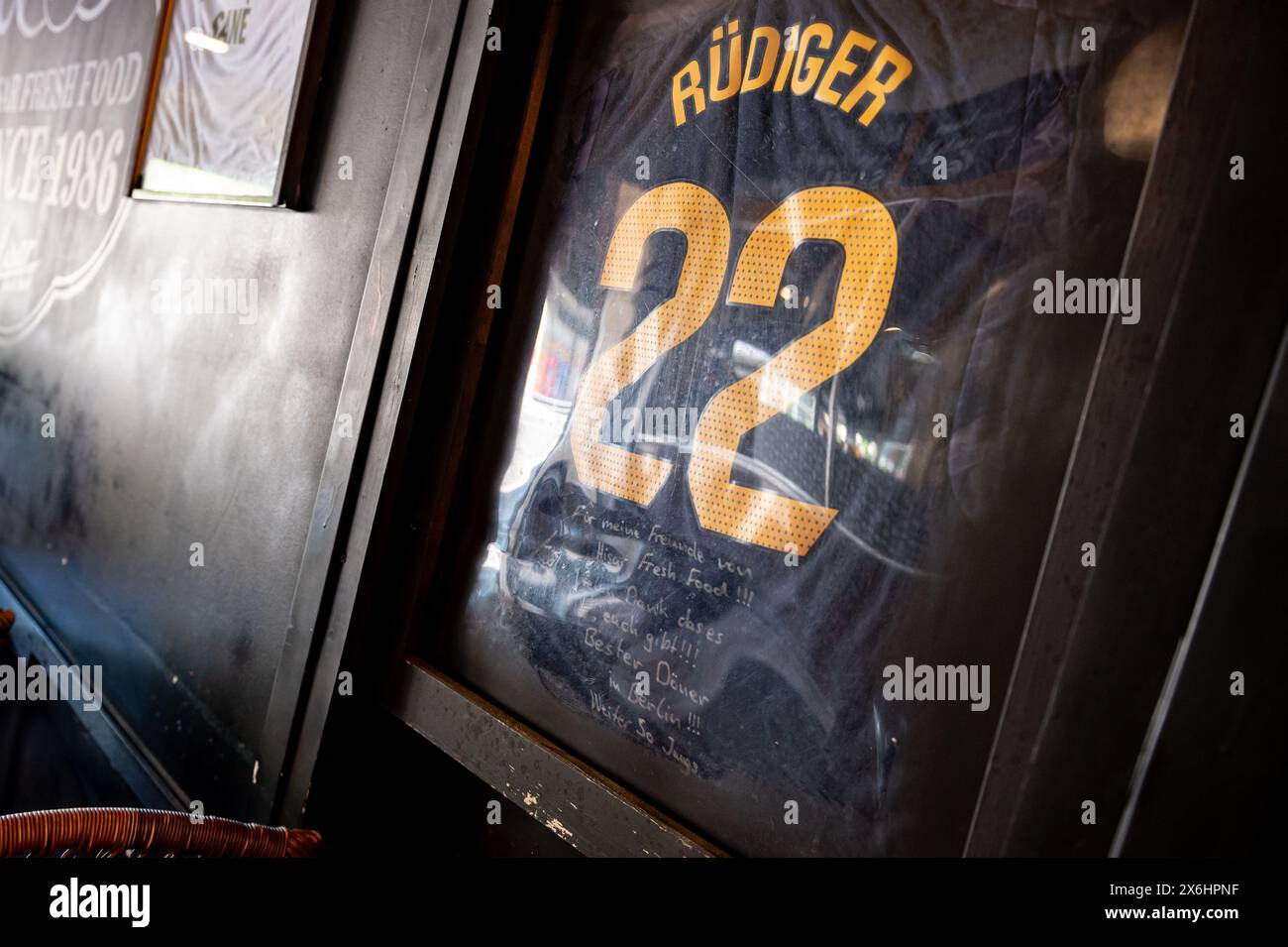 Berlin, Allemagne. 15 mai 2024. Un maillot du joueur national allemand Rüdiger avec un dévouement personnel est accroché au snack-bar kebab 'Hisar Fresh Food' dans le quartier de Kreuzberg. Après que Rüdiger ait été nominé pour le Championnat d'Europe, le propriétaire de l'ancien restaurant préféré du joueur a distribué des kebabs gratuits à 50 écoliers. Crédit : Fabian Sommer/dpa/Alamy Live News Banque D'Images