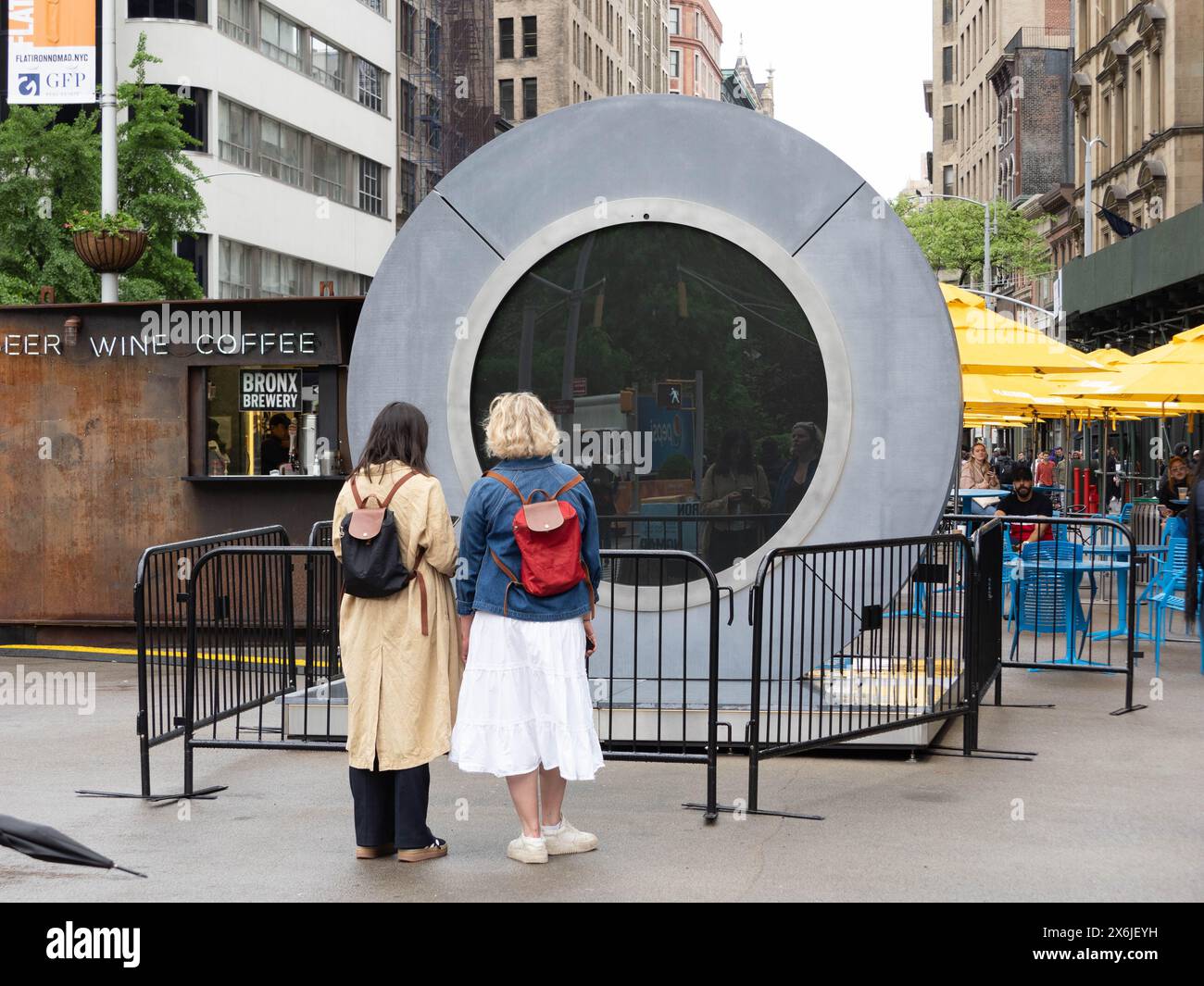 15 mai 2024, New York, New York, USA : les touristes regardent leur reflet au lieu de Dublin. La vidéo en direct reliant des personnes de New York et Dublin a été temporairement suspendue en raison d'un comportement inapproprié. Les gens qui clignotent et montrent des images inappropriées étaient parmi les raisons. Dévoilé en mai 2024, le NYC Portal se dresse fièrement sur l’emblématique Flatiron Plaza, s’ancrant dans le cœur animé de Manhattan. En tant que troisième Portail dans un réseau mondial de sculptures identiques, il sert de phare de connexion. Positionnés dans les espaces publics, les portails fournissent un flux en direct et non filtré autour du cl Banque D'Images