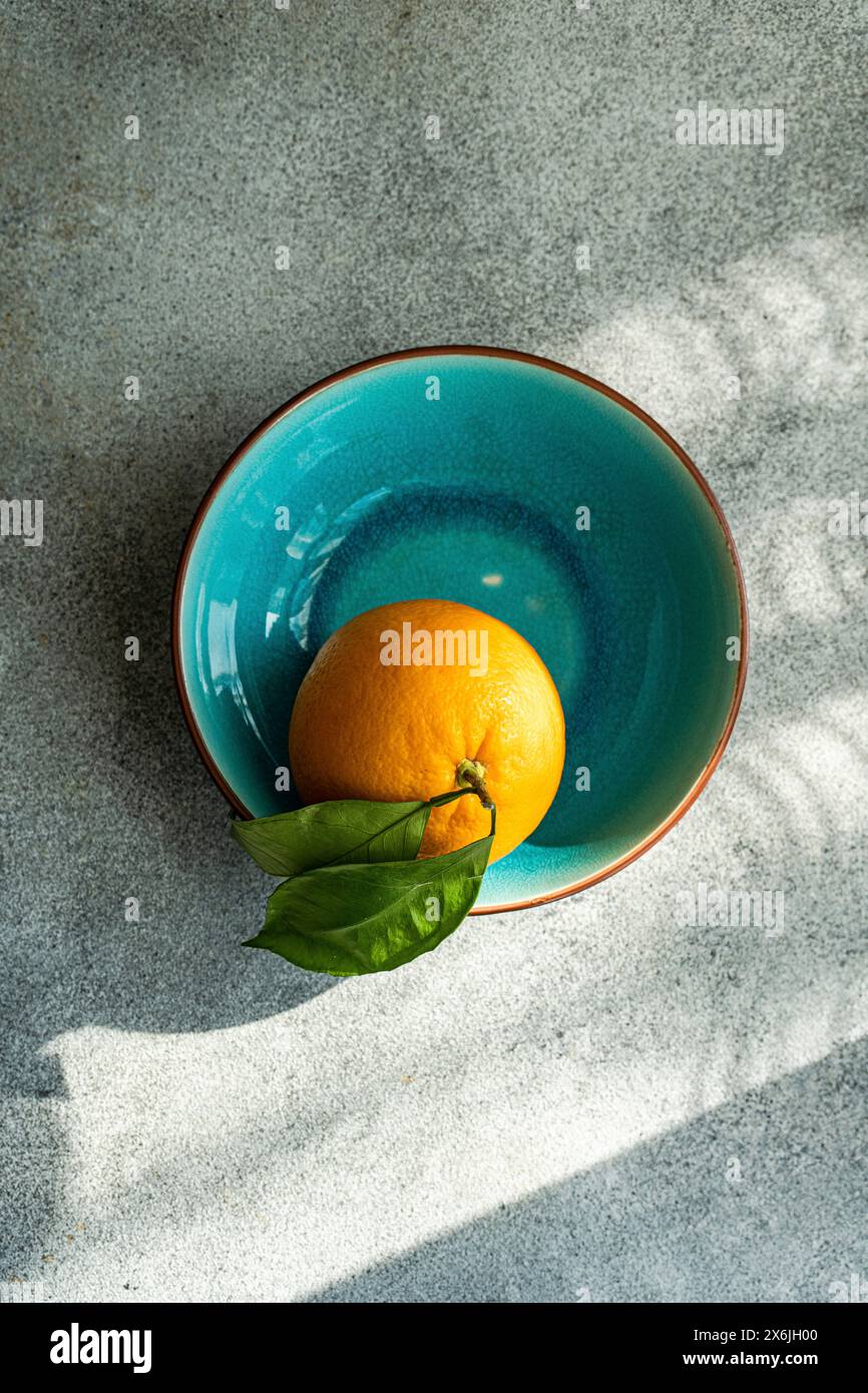 Orange avec des feuilles dans un bol en céramique Banque D'Images