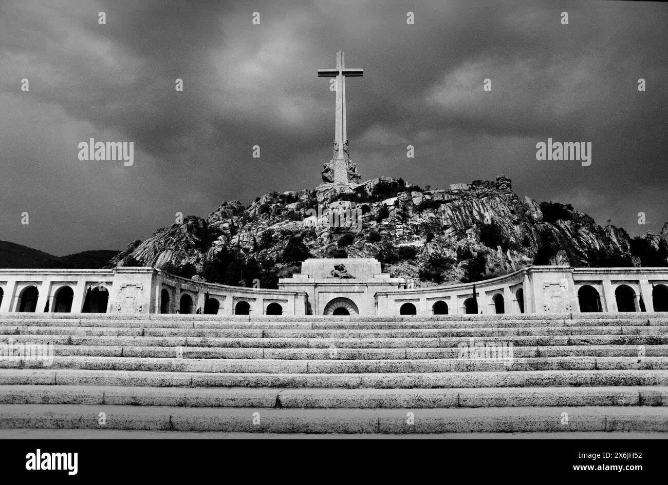 Spain Valley of the Fallen Sierra de Guadarrama 1987 scannée 2024 L'une des plus grandes basiliques du monde s'élève au-dessus de la vallée avec la plus haute croix commémorative du monde. La Basílica de la Santa Cruz del Valle de los Caídos (basilique de la Sainte-Croix de la Vallée des morts) est taillée sur une crête de granit. La croix de 150 mètres de haut (500 pieds) est construite en pierre la vallée de Cuelgamuros (en espagnol : Valle de Cuelgamuros), anciennement connue sous le nom de Vallée des morts (en espagnol : Valle de los Caídos), est un monument dans la Sierra de Guadarrama, près de Madrid. La vallée contient un BA catholique Banque D'Images