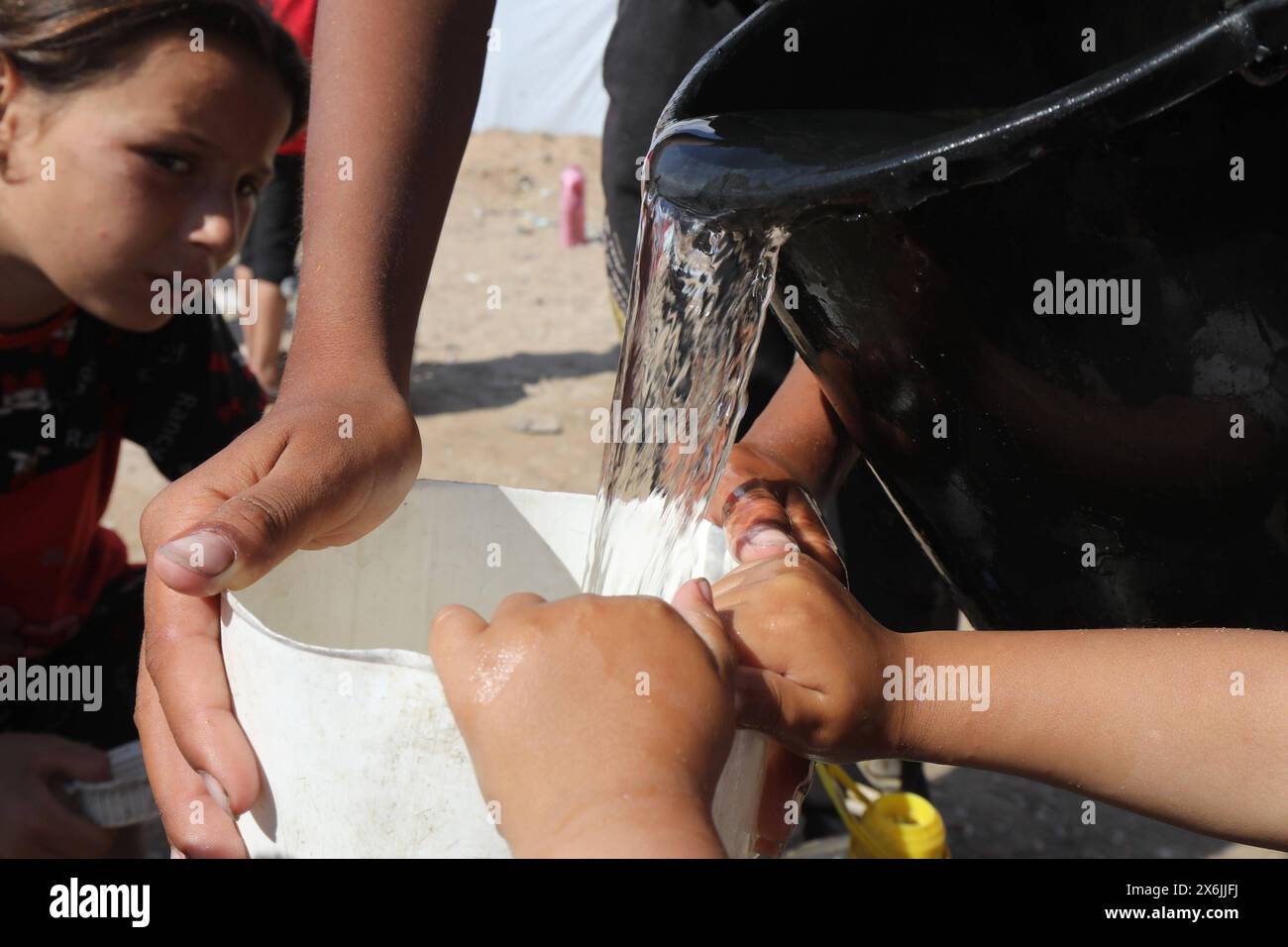 Les Palestiniens déplacés attendent pour obtenir de l'eau d'un puits traditionnel les Palestiniens déplacés attendent pour obtenir de l'eau d'un puits traditionnel creusé à l'intérieur d'un camp pour accueillir les déplacés à Deir al-Balah, dans le centre de la bande de Gaza, le 15 mai 2024. Les personnes déplacées ont recours à creuser des puits souterrains à des mètres de profondeur en raison de la rareté de la disponibilité de l'eau, ils utilisent des outils primitifs dans le processus de creusement. Photo de Omar Ashtawy apaimages Deir al-Balah Gaza Gaza Gaza Territory 150524 dair El-Balah OSH 0051 Copyright : xapaimagesxOmarxAshtawyxxapaimagesx Banque D'Images