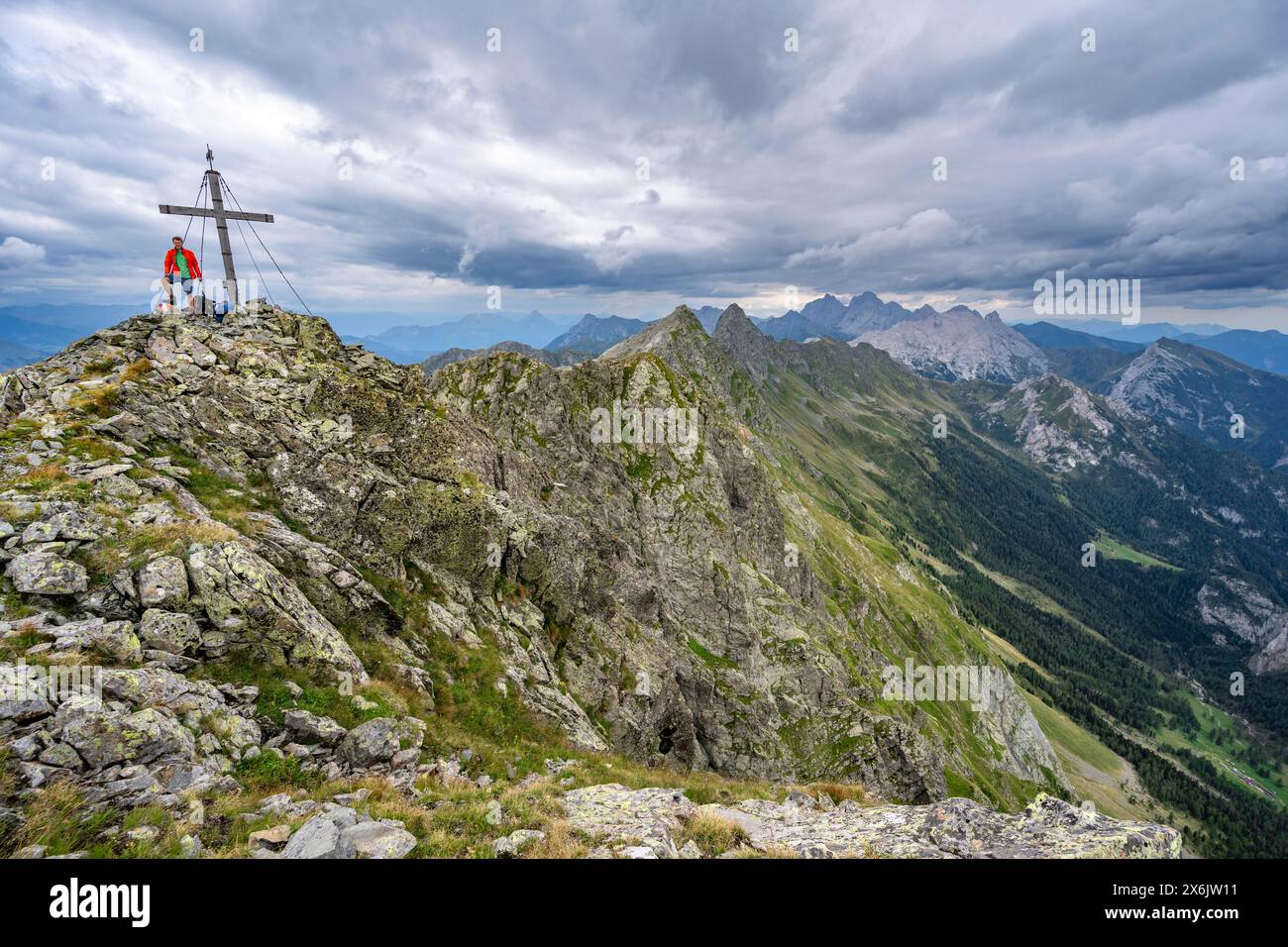 Alpiniste sur le sommet pointu rocheux de la Raudenspitze ou Monte Fleons avec sommet cross, panorama de montagne sur la crête principale de Carnic, Carnic Banque D'Images