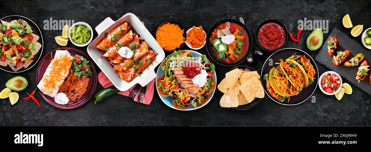 Scène de table de nourriture mexicaine. Vue de haut en bas sur un fond de bannière de pierre sombre. Tacos, assiette burrito, nachos, enchiladas, soupe de tortilla et salade. Banque D'Images