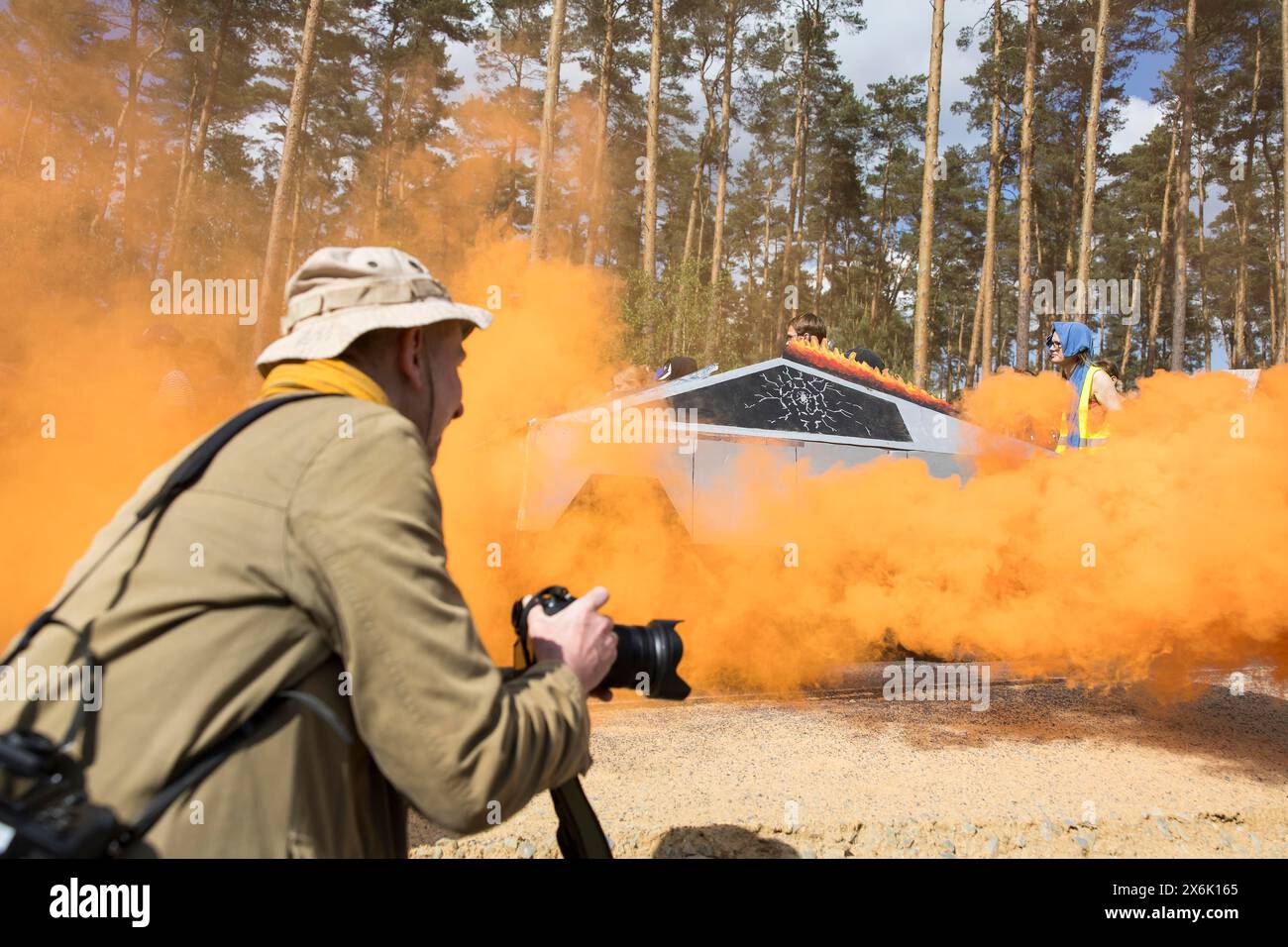 Un Tesla Cybertruck fait de carton entre la fumée d'un pot de brouillard orange pendant l'eau de démonstration. Forêt. Justice contre l'expansion de Banque D'Images