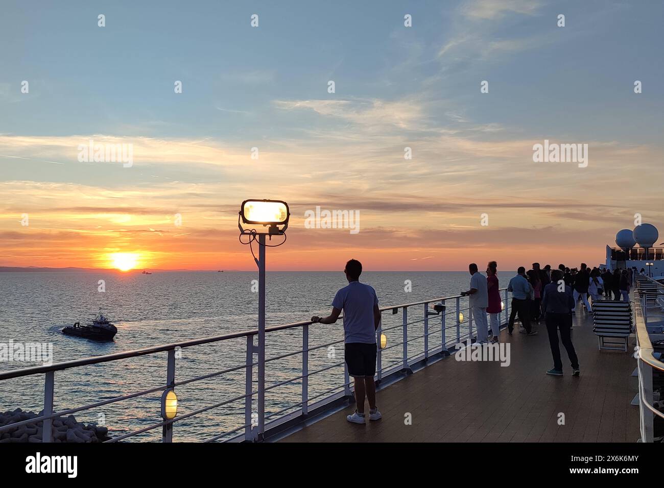 Italie - 07 mai 2024 : les passagers profitent du coucher de soleil pendant leurs vacances depuis un bateau de croisière et regardent la mer *** Passagiere genießen den Sonnenuntergang à Ihrem Urlaub von einem Kreuzfahrtschiff und Blicken auf das Meer Banque D'Images