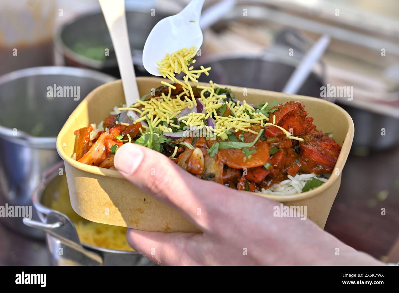 Gros plan sur les plats indiens à emporter, le curry avec du riz, dans un bol en carton pour répondre aux directives britanniques modernes sur les déchets, depuis le stand du marché Banque D'Images