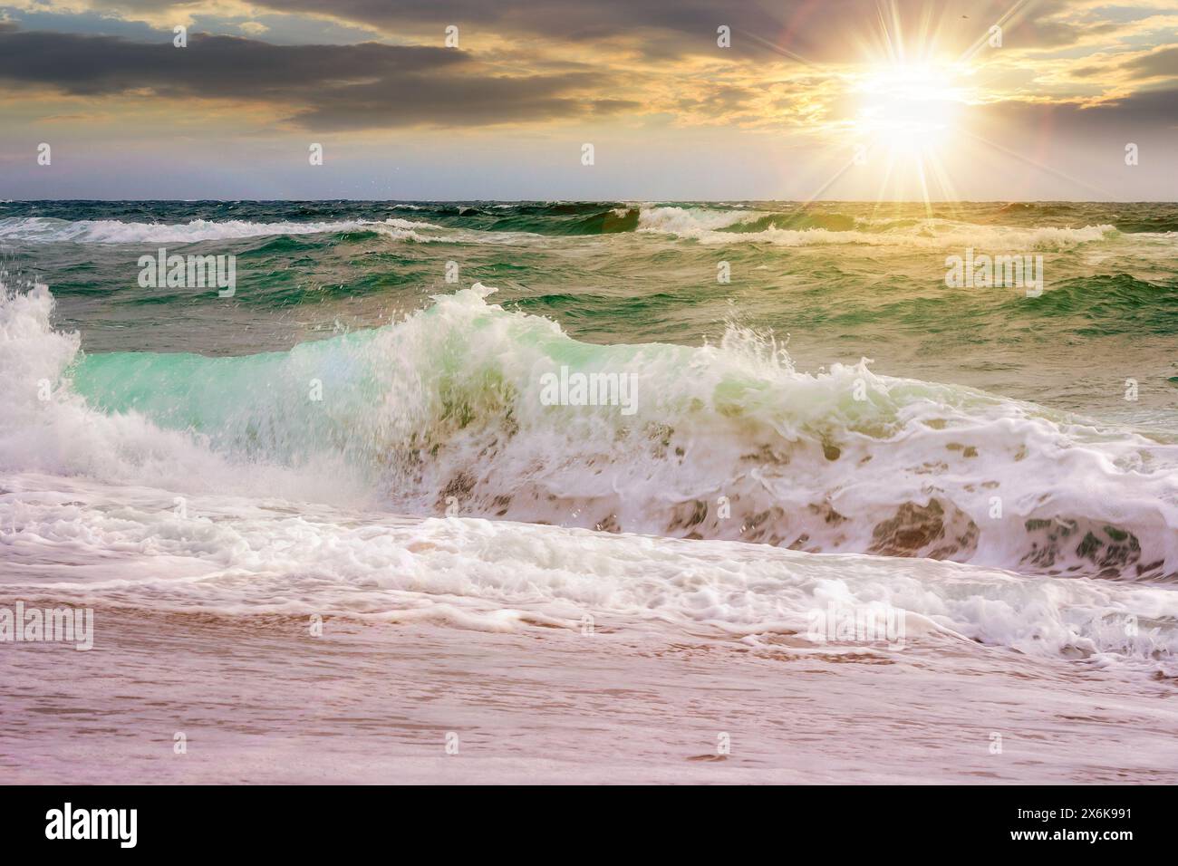 paysage marin avec des vagues écrasant la plage au coucher du soleil. beau paysage d'été à la mer dans la lumière du soir Banque D'Images
