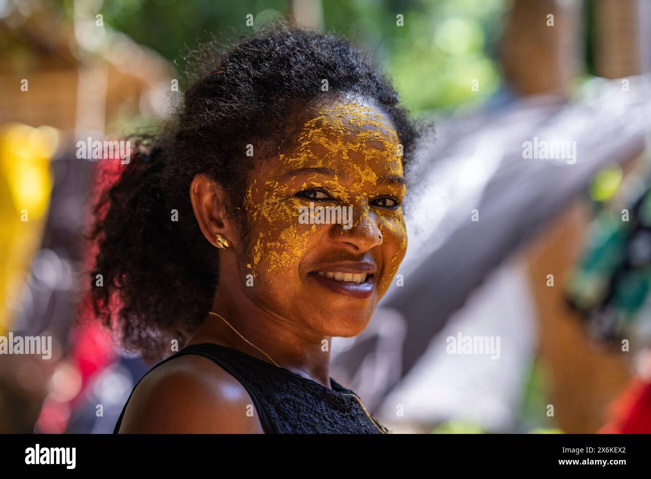 Femme heureuse utilisant la peinture pour le visage Masonjoany comme crème solaire, Nosy Komba, Diana, Madagascar, Océan Indien Banque D'Images