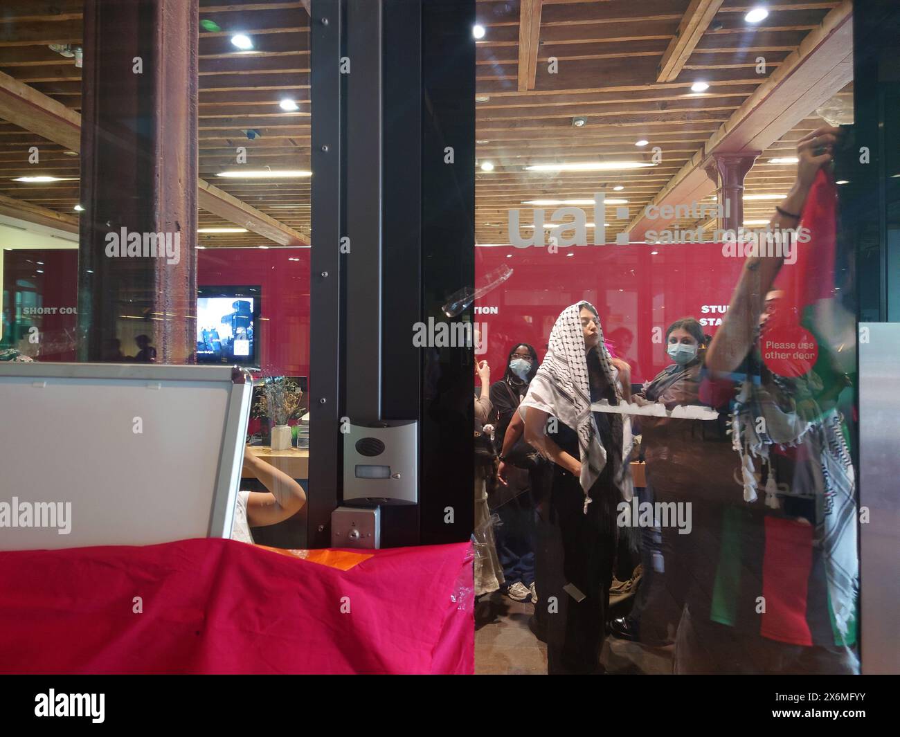 Londres, Royaume-Uni. 15 mai 2024 suite à une manifestation sur le campus de High Holborn, un match d'étudiants s'est terminé à Central Saint Martins, CSM près de King's Cross, où les manifestants ont produit des sacs de couchage et d'autres équipements pour installer un campement, reflétant les actions observées dans de nombreuses autres universités et collèges à travers le monde. Des banderoles ont été placées sur le verre autour de la réception du bâtiment, déclarant certaines des revendications, ainsi que des drapeaux palestiniens. © Amstel Adams/ Alamy Live News Banque D'Images