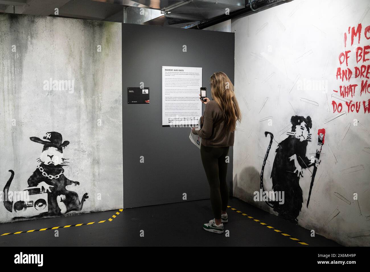 New York, États-Unis. 15 mai 2024. Une femme vue examiner une œuvre d'art du graffiti artiste Banksy recréée pour le musée Banksy à New York le 15 mai 2024 en avant-première de presse. Banksy est un célèbre graffeur britannique qui a créé du Street art à Londres, Bristol, Paris, New York, Kiev et bien d'autres endroits. L’exposition recrée son art de rue ainsi que ses œuvres d’atelier. (Photo de Lev Radin/Sipa USA) crédit : Sipa USA/Alamy Live News Banque D'Images